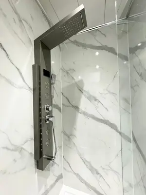 a shower in a bathroom with white marble at Murrayfield Park Guest House in Edinburgh