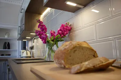 a loaf of bread sitting on a counter with a vase of flowers at Kirk View Apartment in Stirling