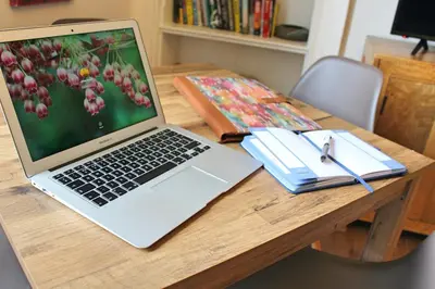 a laptop computer sitting on top of a wooden table at Kirk View Apartment in Stirling