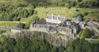 an old castle on top of a hill with trees at Kirk View Apartment in Stirling