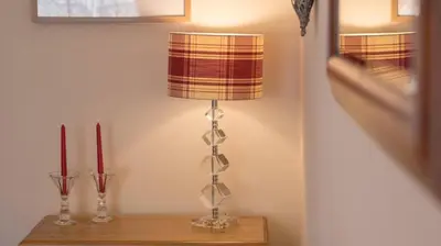 a lamp sitting on top of a table with a candle at Pippin, Tranquil Scottish Cottage with Hot Tub in Airdrie