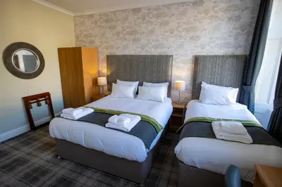 a hotel room with two beds and a mirror at The Waverley Hotel in Callander