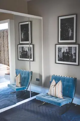 a living room with a mirror and a blue couch at The Rutland Hotel & Apartments in Edinburgh