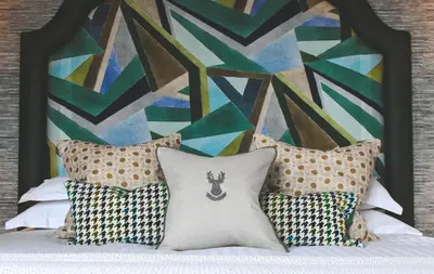 a bedroom with a bed with pillows and a painting at The Rutland Hotel & Apartments in Edinburgh