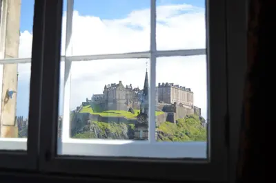 a view of a castle through a window at The Rutland Hotel & Apartments in Edinburgh