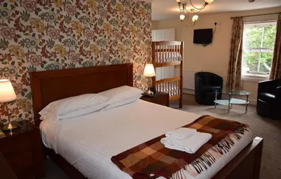a bedroom with a bed with two towels on it at Elphinstone Hotel in Biggar