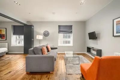 a living room with a couch and a chair at Destiny Scotland -The Malt House Apartments in Edinburgh