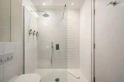 a white bathroom with a shower and a toilet at Destiny Scotland -The Malt House Apartments in Edinburgh