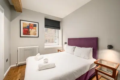 a bedroom with a large bed with towels on it at Destiny Scotland -The Malt House Apartments in Edinburgh
