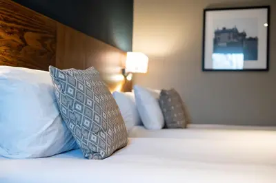 a bedroom with a bed with white pillows and a picture at Toby Carvery Strathclyde, M74 J6 by Innkeeper's Collection in Motherwell