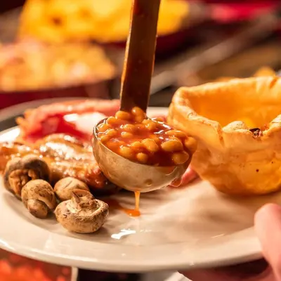 a plate of food with a spoon with beans in it at Toby Carvery Strathclyde, M74 J6 by Innkeeper's Collection in Motherwell
