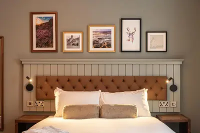 a bedroom with a bed with four pictures on the wall at The Hawes Inn by Innkeeper's Collection in Queensferry