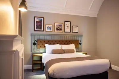 a bedroom with a large bed and some pictures on the wall at The Hawes Inn by Innkeeper's Collection in Queensferry