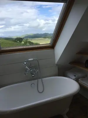 a bath tub in a bathroom with a window at Winterton in Lochgilphead