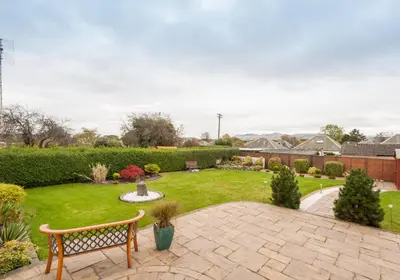 a garden with a bench and a lawn with a fountain at The Traquair Park Residence in Edinburgh