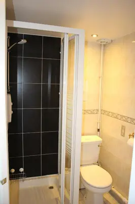 a bathroom with a toilet and a glass shower at Ardmillan Hotel in Edinburgh
