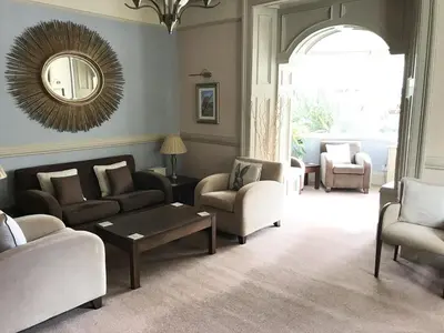 a living room with couches and chairs and a mirror at The Abbotsford in Callander