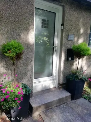 a front door of a house with potted plants at Lowood Cottage in Edinburgh