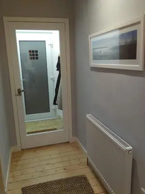 a door leading to a bathroom with a mirror at Lowood Cottage in Edinburgh
