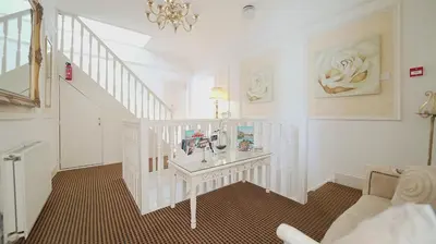 a white room with a white table and stairs at The Old Tramhouse Self Catering Apartments in Stirling
