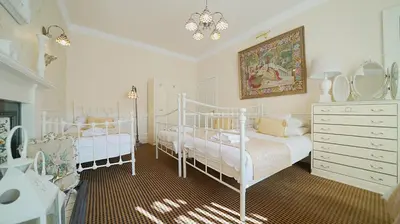a bedroom with two beds and a dresser with mirrors at The Old Tramhouse Self Catering Apartments in Stirling