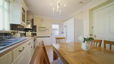 a kitchen with a wooden table and a vase of flowers at The Old Tramhouse Self Catering Apartments in Stirling