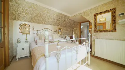 a bedroom with a white bed and a mirror at The Old Tramhouse Self Catering Apartments in Stirling