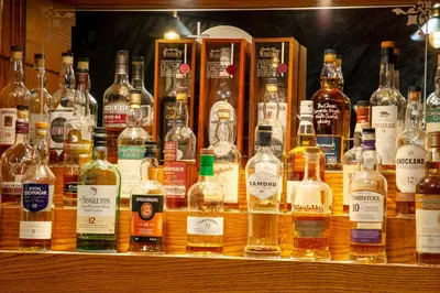 a display of many bottles of whiskey on a shelf at The Galley Of Lorne Inn in Ardfern