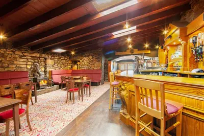 a restaurant with a bar and some tables and chairs at The Galley Of Lorne Inn in Ardfern