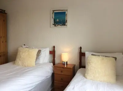 a bedroom with two beds and a lamp on a night stand at Ashbank Hotel in Carradale