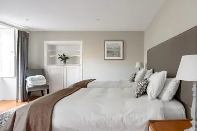 a bedroom with a large bed with white sheets at Drylaw House, Grade A Listed Mansion near City Centre in Edinburgh