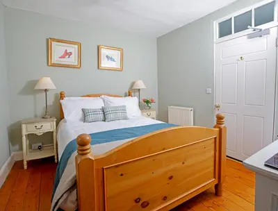 a bedroom with a wooden bed with a wooden floor at Drylaw House, Grade A Listed Mansion near City Centre in Edinburgh