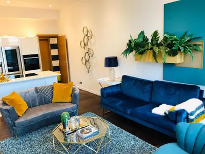 a living room with two blue couches and a table at 2 bed Chic Apartment in Glasgow City Centre in Glasgow
