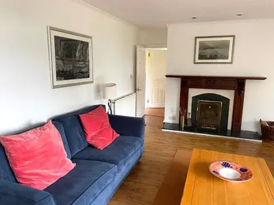 a living room with a blue couch and a fireplace at Shore House in Tarbet