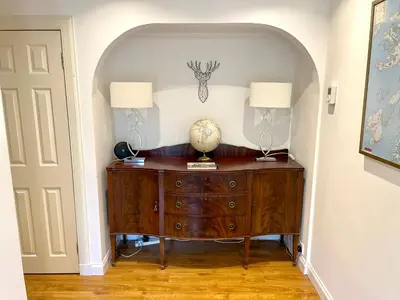 a room with a wooden dresser with two lamps on it at Shore House in Tarbet