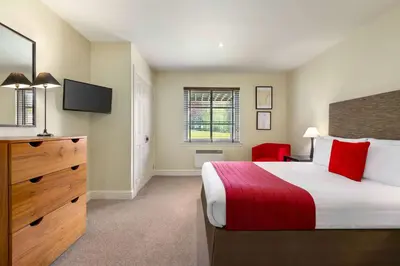 a hotel room with a bed and a tv at Wyndham Duchally Country Estate in Auchterarder