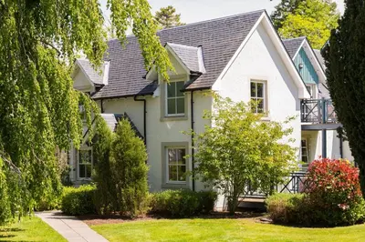 a white house with a yard at Wyndham Duchally Country Estate in Auchterarder