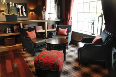 a waiting room with chairs and a table and a window at Eglinton Arms Hotel, BW Premier Collection in East Kilbride