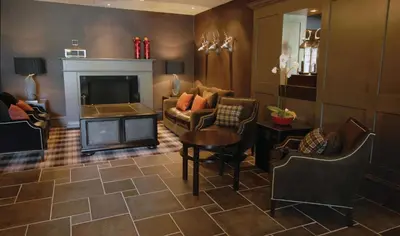 a living room with a couch and a fireplace at Eglinton Arms Hotel, BW Premier Collection in East Kilbride
