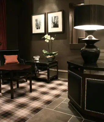 a living room with a table and chairs and a lamp at Eglinton Arms Hotel, BW Premier Collection in East Kilbride