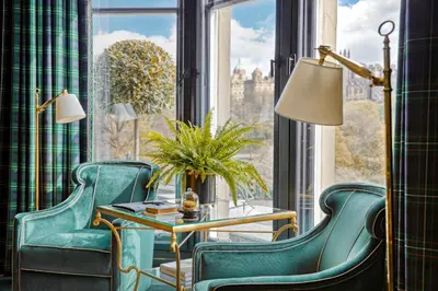 a room with green chairs and a table and a window at 100 Princes Street in Edinburgh