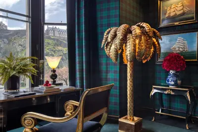 a room with a desk and a chair and a floor lamp at 100 Princes Street in Edinburgh