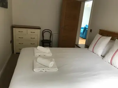 a bedroom with two white towels on a bed at Trinity Lodge - Home with Private Garden and Parking in Edinburgh