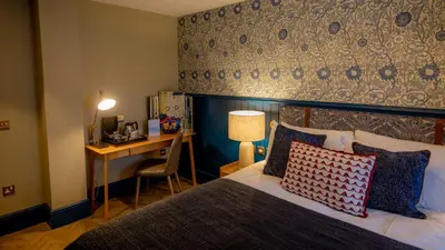a hotel room with a bed with a desk and a desk at Brisbane House Hotel in Largs