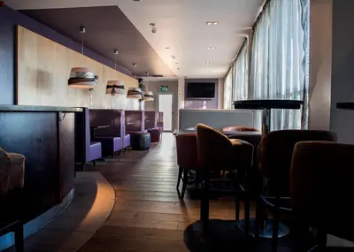 a restaurant with a bar with chairs and tables at Avonbridge Hotel in Hamilton