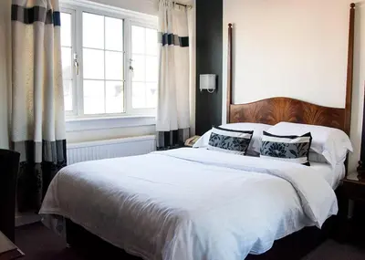 a bedroom with a large bed with white sheets and pillows at Avonbridge Hotel in Hamilton