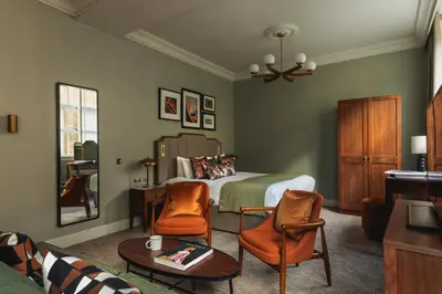 a bedroom with a bed and two chairs at Native Glasgow in Glasgow