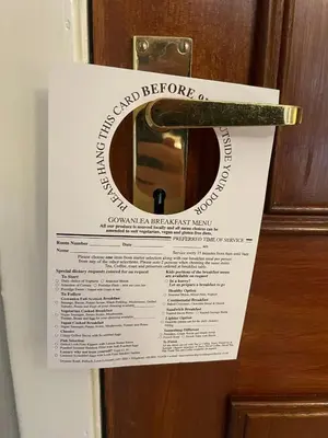 a sign is taped to a door with a door knob at Gowanlea Guest House in Balloch