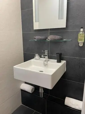 a bathroom with a white sink and a mirror at Gowanlea Guest House in Balloch