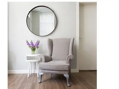 a chair and a table with a mirror at The Lane Apartment in Edinburgh